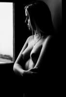 Eine junge Frau steht nackt an einem Fenster. Das Foto ist in Schwarz-Weiß. Fotograf: Harald Baumeister aus Freinsheim.